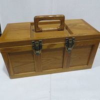 Closed wooden toolbox front view showing two latches and carry handle