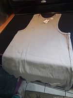 Full view of tank top laid flat showing overall color, ribbed texture and tags