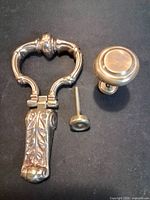 Door knocker, knob, bolt and strike cap grouped on black surface