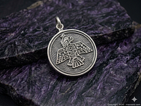Front view of sterling silver thunderbird charm on stone background
