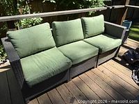 Front view of three-seat wicker sofa with green cushions