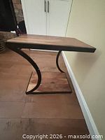 Full view of end table showing wood top, curved metal frame and base shelf