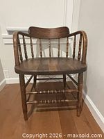 Front angled view showing spindle back, armrests, turned legs, oak stain finish