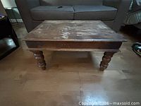 Front view of square coffee table showing turned legs and distressed top