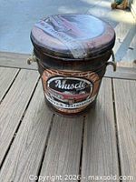 Top view of round metal stool showing padded lid graphic