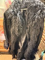 Full view of black faux fur coat front with lining visible