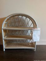 Front view of rattan shelf with three tiers and tags attached