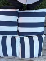 Four navy and white striped seat cushions stacked