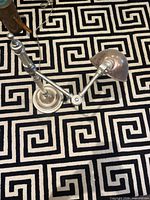 Lamp top view showing articulating arm and dome shade on patterned rug