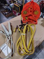 Lot overview: cord reel with extension cord, jumper clamps, two power strips