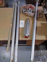 Overall lot showing three pole sections, ruler for scale, ground stake
