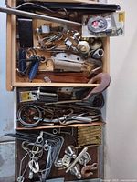 Top-view of drawer showing mixed springs, hooks, brackets, knobs, Hopkins cord kit, metal files and tool boxes