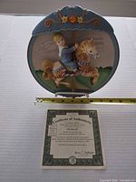 Front view of Carousel Daydreams "All Aboard!" plate with certificate and ruler for scale
