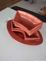 Stacked wedge bowls atop oval platter showing color and shape