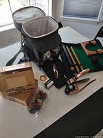 Overview of lot with cooler bag, wine openers, putting set case, boxes of table weights