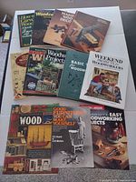 Overhead view of all twelve woodworking and woodcarving books laid out on table
