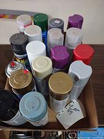 Top view of box showing majority of aerosol cans and cap colors