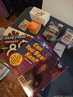 Overview showing Trivial Pursuit Totally 80s, Can You Beat Ken?, Total Football Trivia tin, CinePlex Movies cube, Christmas Trivia boxes and wrapped deck