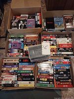 Four cartons of assorted VHS tapes showing variety of slipcases and titles