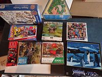All nine puzzle boxes arranged on table, showing fronts and artwork