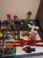 Overview of loose figures, vehicles, accessories on table
