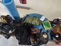 Overview of lot showing foam pad, tent, gaiters, camo pouch, traction cleats, cord coil, growler