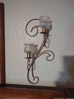 Single metal scroll wall sconce with ribbed glass candle cup
