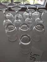 Overview of 9 of the 12 glasses upside down, showing gold rims and etched design