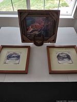 Full lot view showing three framed pieces and horseshoe stand