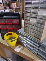 Overview of three organizers and yellow bucket on workbench