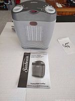 Front view of Sunbeam ceramic heater and instruction leaflet
