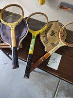 Three rackets with covers and press laid out