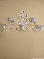 Front view of white metal 5-arm sconce with glass cups installed