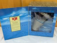 Closed presentation box open to show space capsule through window