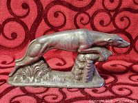 Right-front view of cast metal leaping hound on base