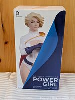 Front of boxed Power Girl statue showing product name and artwork