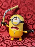 Front view of Minion figure displaying eye, goggle, whip accessory and body details