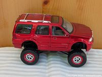 Left front view of red lifted Lincoln Navigator die-cast model