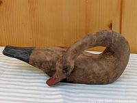 Full side view of wooden goose carving showing curved neck and painted details
