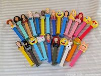 All 25 PEZ dispensers laid out on striped background