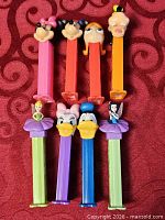 All eight Disney PEZ dispensers front view