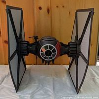 Front view of large scale TIE Fighter showing cockpit, wings, red accent