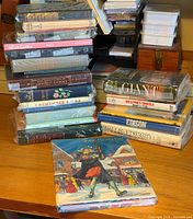 Stacked shrink-wrapped hardcover books left side, titles visible