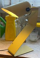 Full view of metal task lamp showing Z-shaped body and lit conical shade