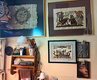 Group view showing framed papyrus pieces, relief plaques, pharaoh head plaque, and portion of ceramic vase