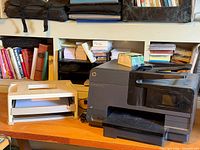 HP Officejet Pro 8610 printer and beige two-tier letter tray on desk