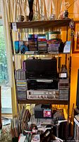 Full view of shelf showing stereo system, CDs, DVDs, vinyl and decor items
