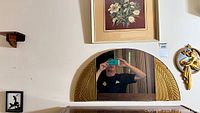 Overall wall section showing floral print, mirror, plaque, shelf, silhouette