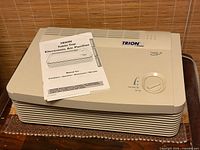 Top view of Trion air purifier with manual on unit