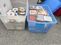 Two storage totes filled with CDs, showing overall quantity and container types